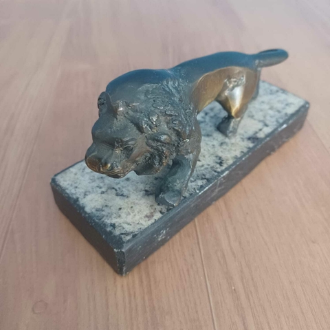 Escultura antiga de leão em bronze sobre base de mármore