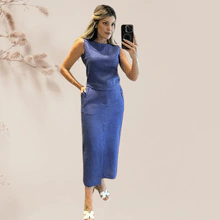 Modelo vestindo um conjunto de linho composto por saia e top em tom azul.