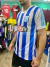 Camiseta retro de Racing Club con franjas verticales en azul y blanco, exhibiendo el logo de Rosamonte en el centro.