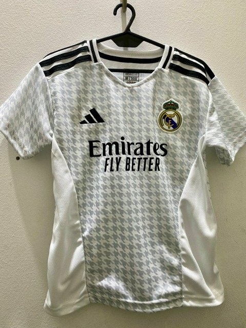 Camiseta del Real Madrid para niños en color blanco con detalles en negro y el logo del equipo.