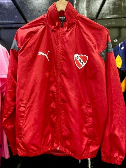 Rompeviento rojo del club Independiente, con logo y detalles de la marca Puma.
