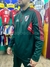 Buzo de entrenamiento con medio cierre, color verde, de River Plate, con detalles rojos y logo del club.