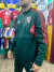 Buzo de entrenamiento con medio cierre, color verde, de River Plate, con detalles rojos y logo del club.