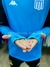Buzo polera de Racing en color azul, con mangas largas y detalles en la parte inferior de las mangas.