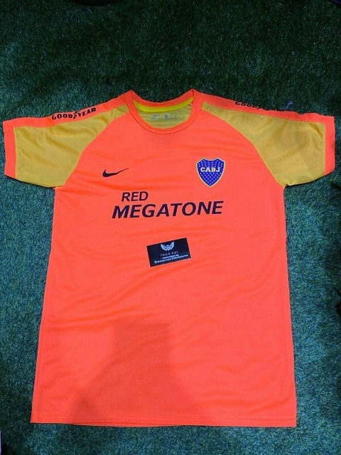 Camiseta de arquero suplente de Boca Juniors, color naranja y amarillo, con el logo de Nike y la inscripción "RED MEGATONE".