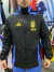 Rompeviento de excelente calidad con colores negro y celeste, exhibiendo el logo de la AFA y la marca Adidas.