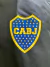 Logo de Boca Juniors en un rompeviento, con fondo negro y detalles en azul y amarillo.