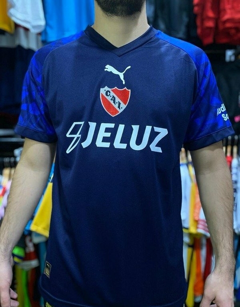 Camiseta alternativa de Independiente azul con logo de Puma y sponsor en el pecho.