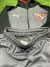 Conjunto de fútbol para niño de Independiente, incluye chaqueta y pantalones cortos en tonos gris y negro.