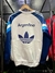 Buzo retro de Argentina 1996 en color blanco, con el logo de Adidas y la inscripción "Argentina" en la parte posterior.