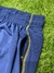 Pantalón de boca azul con detalle de cierre y costura amarilla, sobre fondo de césped artificial.