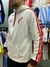 Campera blanca de River Plate, con capucha y franjas rojas en las mangas, vista lateral de un modelo.