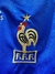 Logo bordado de la selección de fútbol de Francia en una camiseta azul, mostrando un gallo y una estrella dorada.