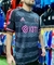 Camiseta negra del Inter de Miami con detalles en rosa, modelo Adidas, exhibida por una persona en una tienda de ropa deportiva.