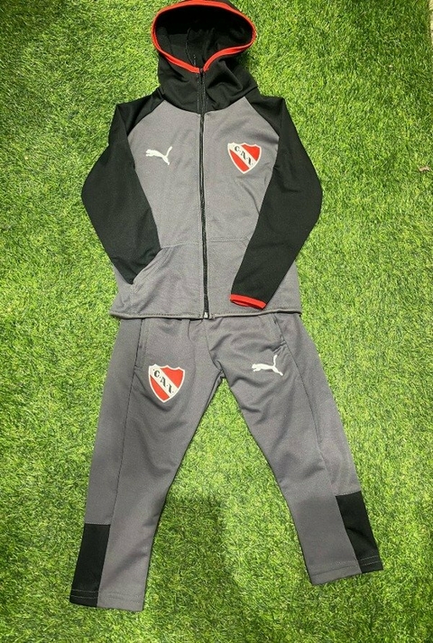 Conjunto de chándal de niño del Club Atlético Independiente, color gris con detalles en negro y rojo, incluye sudadera con capucha y pantalones.