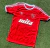 Camiseta roja del club Independiente con logo y sponsor mita, sobre césped.
