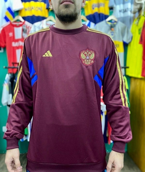Buzo bordó de Rusia con detalles en azul y dorado, modelo de Adidas, visto de frente.