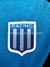 Escudo del club Racing Club en un buzo polera de color azul.