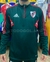 Buzo de entrenamiento de River Plate con medio cierre y diseño en verde y rojo.