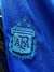 Logo de la Asociación del Fútbol Argentino (AFA) bordado en un short de la selección argentina, con un fondo azul.