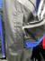 Detalle de la manga de un rompeviento retro negro y azul, con una franja plateada.