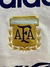 Logotipo bordado de la Asociación del Fútbol Argentino (AFA) en un buzo retro blanco de 1996.