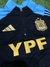 Buzo de niño negro con medio cierre y detalles en azul, logo de la AFA y la inscripción YPF en dorado.