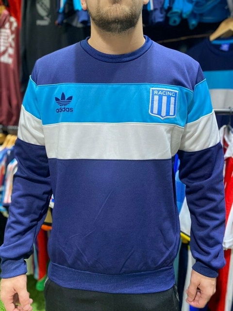 Buzo de Racing tricolor con franjas en azul y gris, modelo de Adidas.