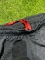 Pantalón negro de River Plate con detalles rojos en la cintura.