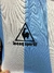 Camiseta de la selección argentina de fútbol con diseño clásico de rayas celestes y blancas, con el logo de le coq sportif.