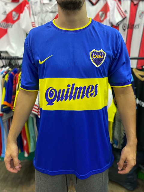 Camiseta retro de Boca Juniors, modelo de 2000, con colores azul y amarillo y el logo de Quilmes en el frente.