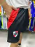 Shorts de River Plate en color negro con detalles rojos y logo del club.