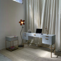 Oficina moderna con escritorio blanco, lámpara decorativa y cortinas claras.