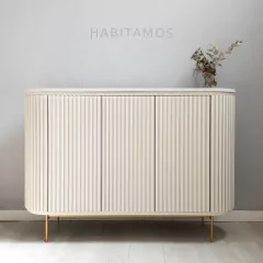 Mueble de almacenamiento de color blanco con diseño de líneas verticales y patas doradas.