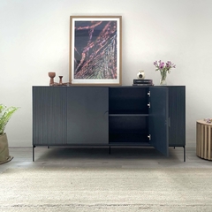 Mueble cómodo de color azul con puertas abiertas, decorado con un cuadro en la pared y flores en la parte superior.
