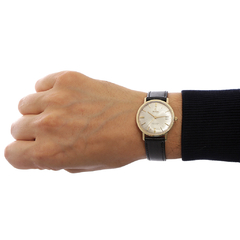 Relógio Omega Seamaster De Ville sendo exibido no pulso de uma pessoa, com mostrador prateado e pulseira de couro preta.