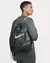 Homem usando uma bolsa sacola Nike na cor camuflada, visto de perfil.