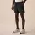 Homem usando shorts masculino preto Fila Diamond Core Run com elástico na cintura e tênis branco