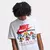 Pessoa vestindo camiseta branca Nike SW M90 Sole Food com estampa colorida e texto em inglês