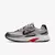 Tenis Nike Initiator na cor prata com detalhes em vermelho e preto, visto de lado.