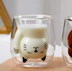 Taza de doble vidrio con diseño de gato sosteniendo leche.
