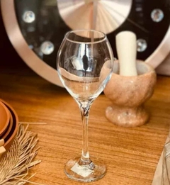 Copa de champagne de vidrio de 350 ml sobre una mesa de madera, junto a un mortero y platos.