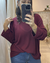 Mujer tomando selfie en espejo vistiendo un buzo Pampa color bordó con textura acanalada y mangas largas