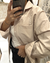 Mujer posando frente a un espejo con la Camisa Kioto beige con rayas blancas, de poplin, corte clásico con bolsillo en el pecho