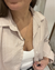 Mujer posando frente a un espejo con la Camisa Kioto beige con rayas blancas, de poplin, corte clásico con bolsillo en el pecho