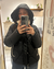 mujer usando campera Nepal negra con detalles de corderito y capucha desmontable