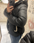 mujer de perfil usando campera Nepal negra con detalles de corderito y capucha desmontable