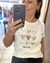 Primer plano de mujer usando remera color off white con estampado de corazones en foil de colores dorado, plateado y marrón, con texto "YOU & ME".
