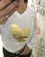 Remera blanca de mujer con estampado dorado en forma de corazón que dice "Je t'aime".