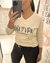 Remera Tokio manga larga beige con estampado "Pura Vida" en el frente, usada por mujer que se toma una selfie frente a un espejo